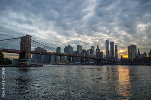 Manhattan Downtown Financial District Skyline and Brooklyn Bridge as Seen from Mainstreet Park in Brooklyn at Sunset, USA