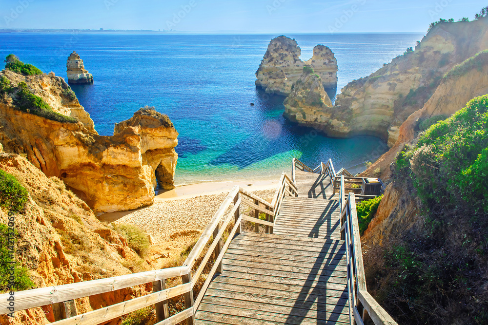 Fototapeta Wooden footbridge to beautiful beach Praia do Camilo near Lagos