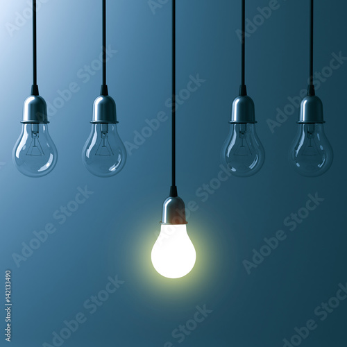 One hanging light bulb glowing different and standing out from unlit incandescent bulbs with reflection on dark cyan background , leadership and different business creative idea concept. 3D rendering. photo