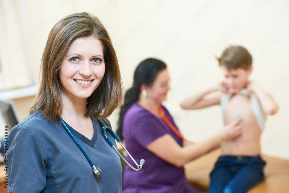 female children's doctor in front of pediatrician little boy examination female children's doctor in front of pediatrician little boy examination