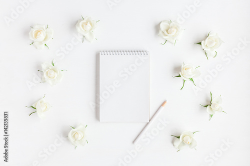 Workspace with notebook, rose flowers, pencil. Wedding concept. Flat lay, top view