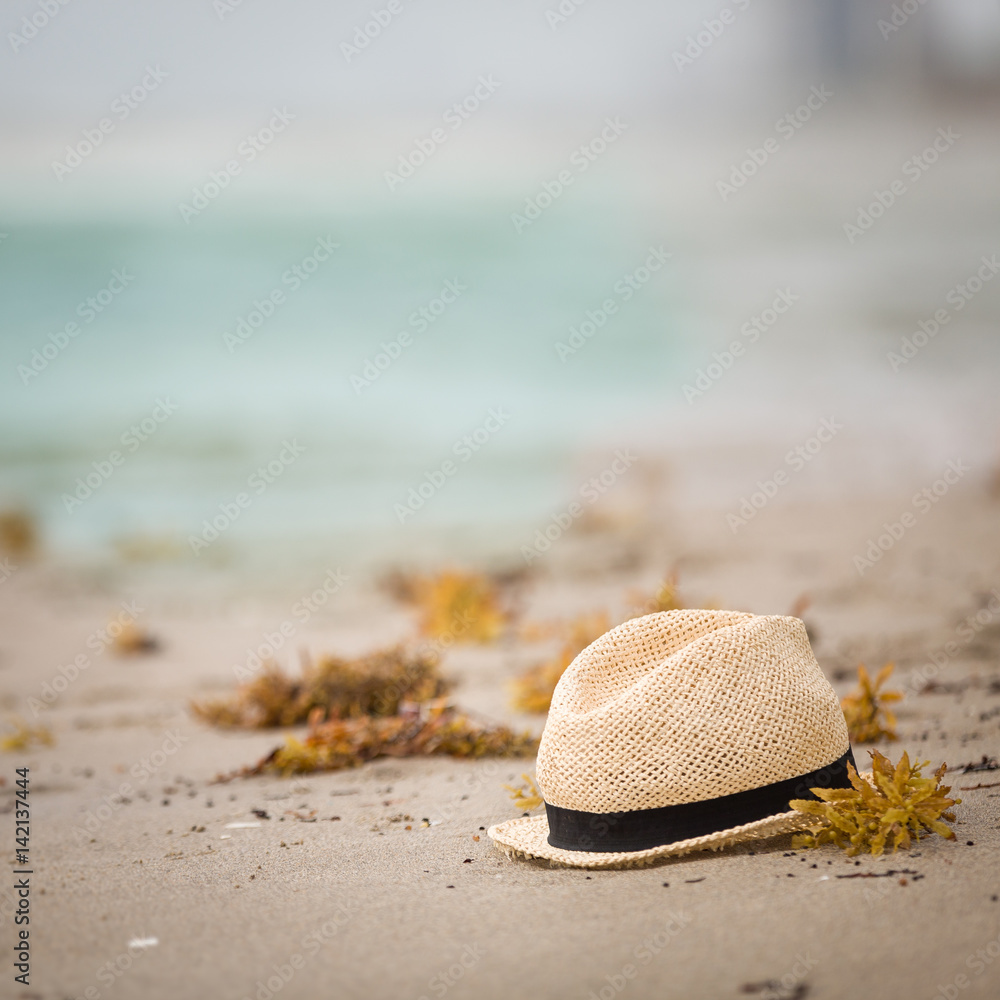 Nice straw hat laying on the sand. Beautiful ocean beach background. Outdoors. Vacation time. End of summer vacations. Dreaming of holidays by the sea. Traveling. Nice straw hat laying on the sand. Beautiful ocean beach background. Outdoors. Vacation time. End of summer vacations. Dreaming of holidays by the sea. Traveling.