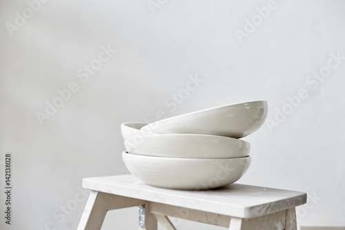 Tela Samples handmade ceramic white plates on wooden table, working process in studio