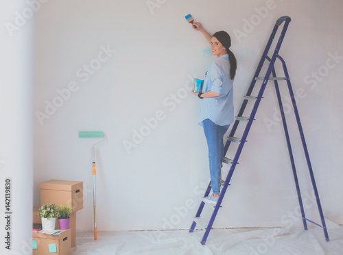 Portrait of happy smiling young couple painting interior wall new house