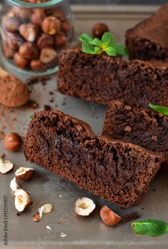 Homemade chocolate brownies with nuts on a metal, grunge background