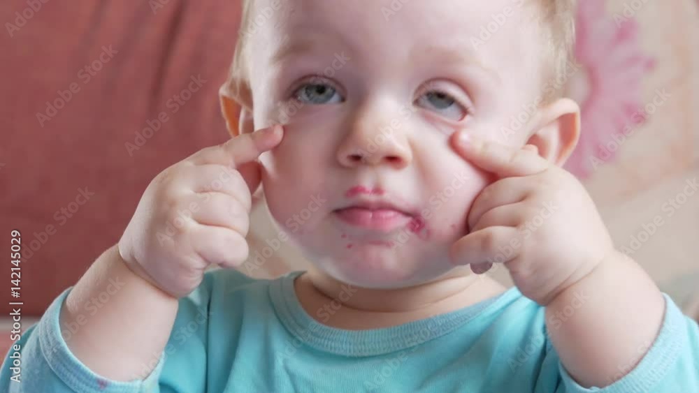 An attractive boy 2 years old eats a red beet salad. The face is smeared with porridge. Sits on the table. An attractive boy 2 years old eats a red beet salad. The face is smeared with porridge. Sits on the table.