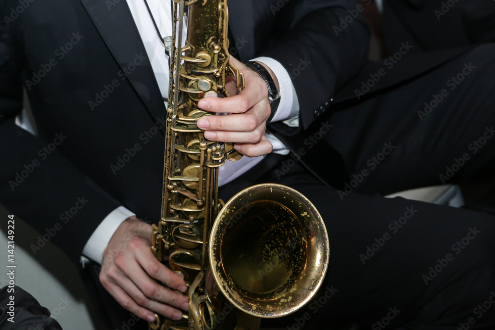Naklejka premium A man playing a saxophone instrument musician