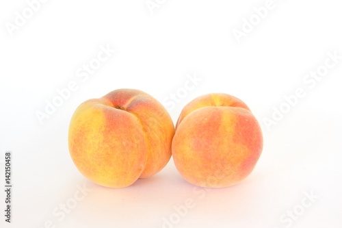 Two fresh whole peaches, isolated on white