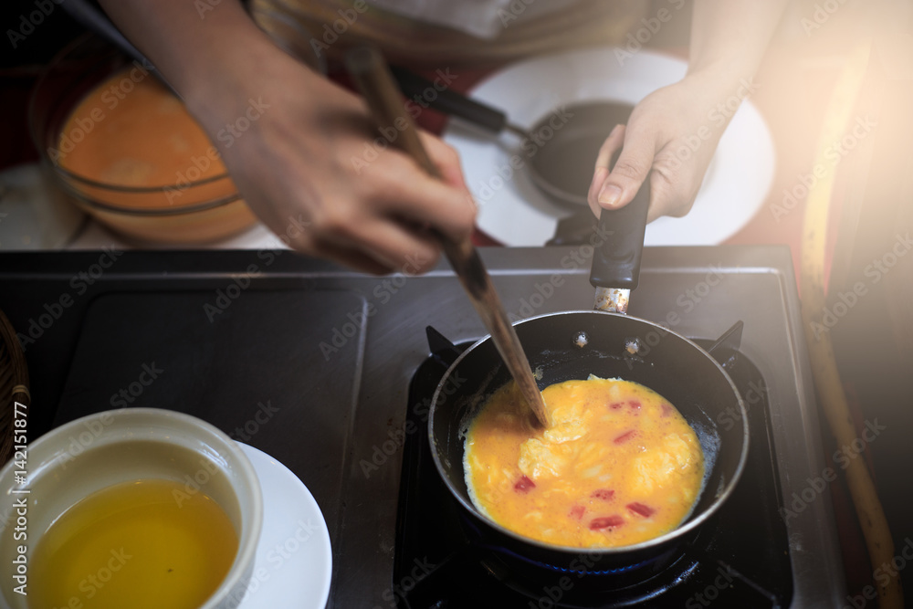 Chef putting egg to pan. Chef putting egg to pan.