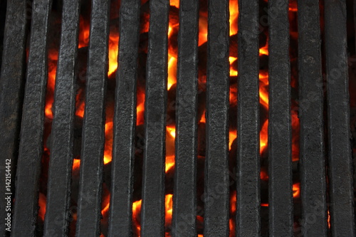 Close-up BBQ grates over blazing charcoal