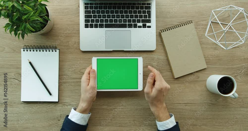 Business man using tablet, scrolling, checking information on tablet with green screen. Hands top view. Office desk background. Slow motion. red epic Business man using tablet, scrolling, checking information on tablet with green screen. Hands top view. Office desk background. Slow motion. red epic