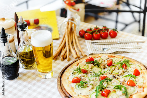 Tasty pizza with glass of beer  on served table