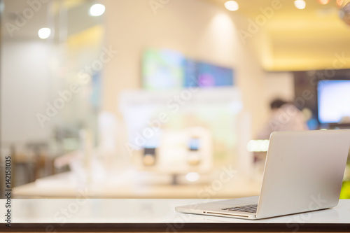 Mock up laptop on white wood top table and office background. for Product display montage © bongkarn