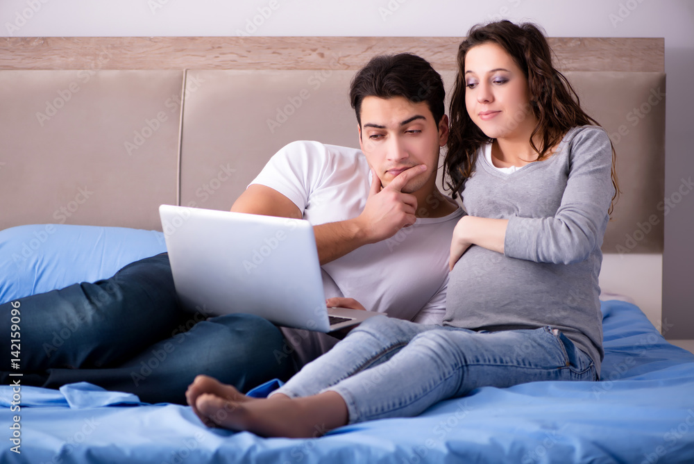 Young family with pregnant wife expecting baby in bed Young family with pregnant wife expecting baby in bed