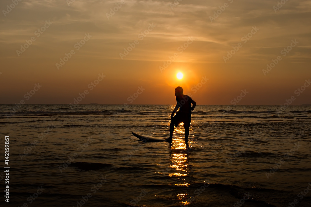 Silhouette summer Of man playing surfboard on sunset beach