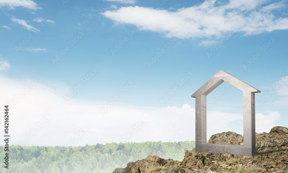 Conceptual image of concrete home sign on hill and natural landscape at background Conceptual image of concrete home sign on hill and natural landscape at background
