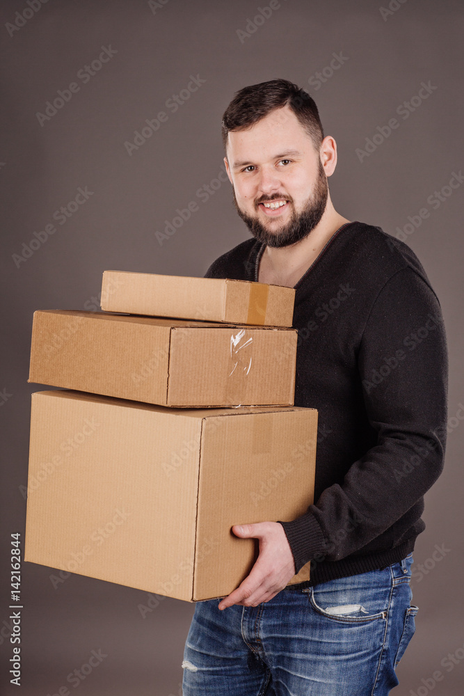 man holding pile of cardboard boxes in front man holding pile of cardboard boxes in front