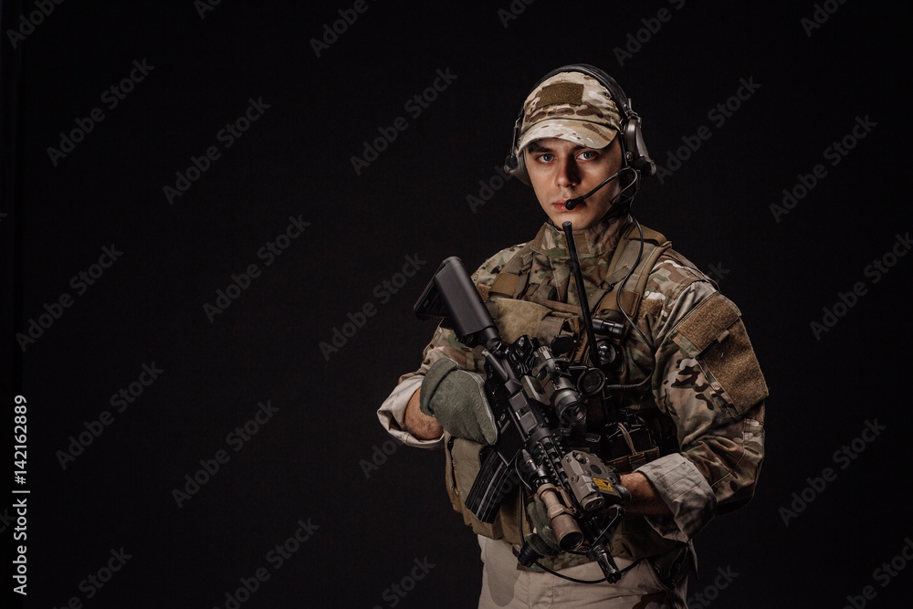 Portrait soldier or private military contractor holding sniper rifle. war, army, weapon, technology and people concept. Image on a black background. Portrait soldier or private military contractor holding sniper rifle. war, army, weapon, technology and people concept. Image on a black background.