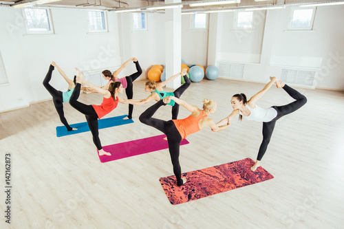 women are practicing yoga exercises in the studio. pair yoga concept.