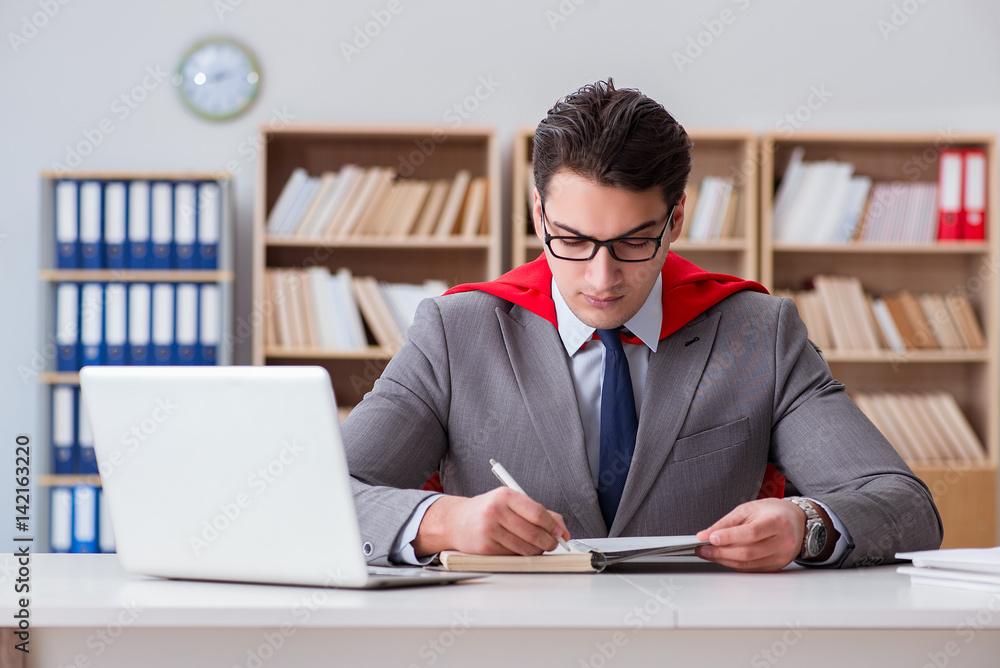Superhero businessman working in the office Superhero businessman working in the office