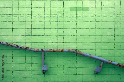 Green stucco wall texture with metal railing for background or copy space. photo
