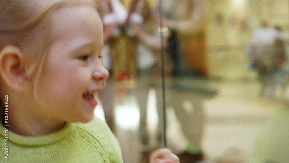 The girl watches the reflection in glass. The girl watches the reflection in glass.
