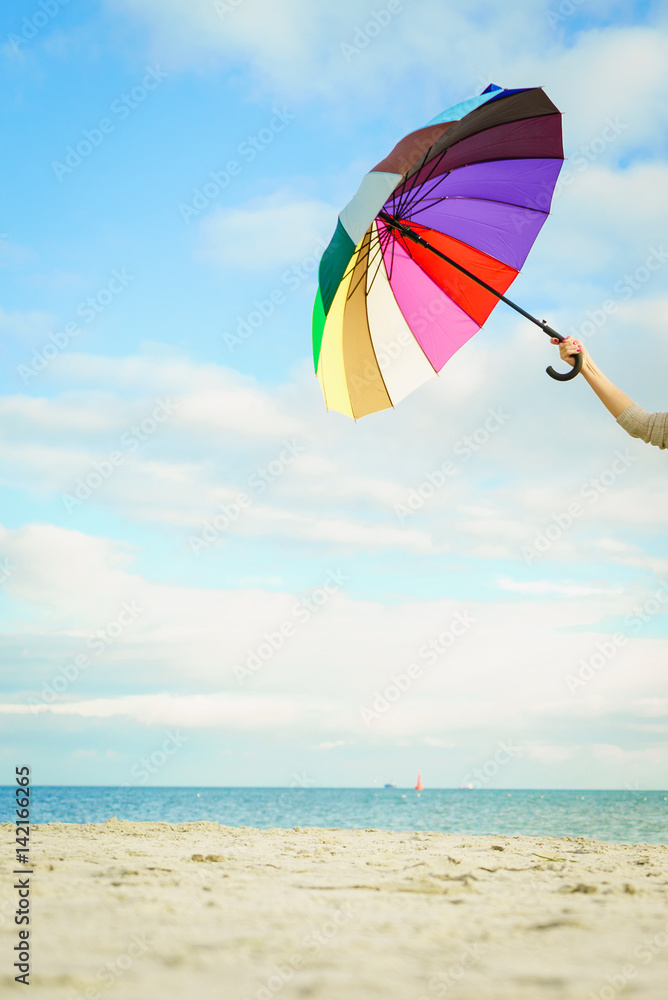 Woman hand holding colorful plastic umbrella
