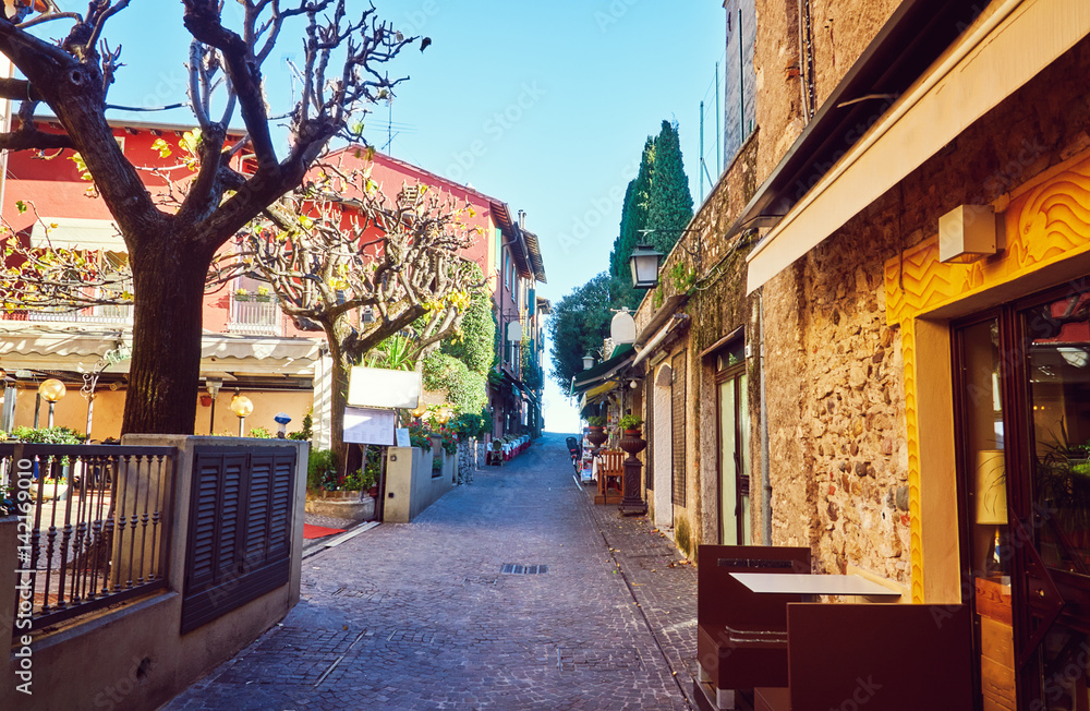 Fototapeta premium Narrow Street restaurant cafeteria Sirmione Lake Garda Italy