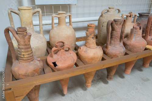 Antique Greek clay amphorae and jugs on desk. Dion, Pieria, Greece.
