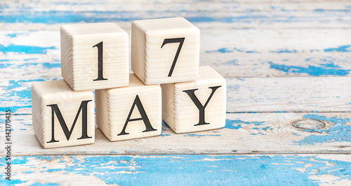 May 17th. Wooden cubes with date of 17 May on old blue wooden background.