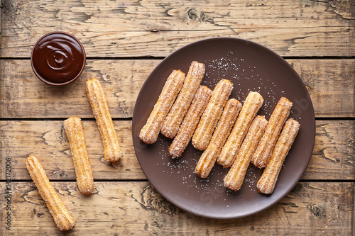Traditional churros Spanish homemade sweet dessert pastry food on vintage wooden table background