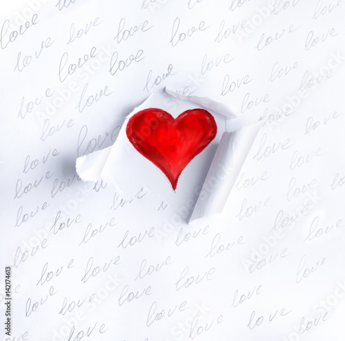 White torn paper with pencil inscriptions "love" and a hole with one painted heart. Concept of template for lovers message. A bright romantic image.