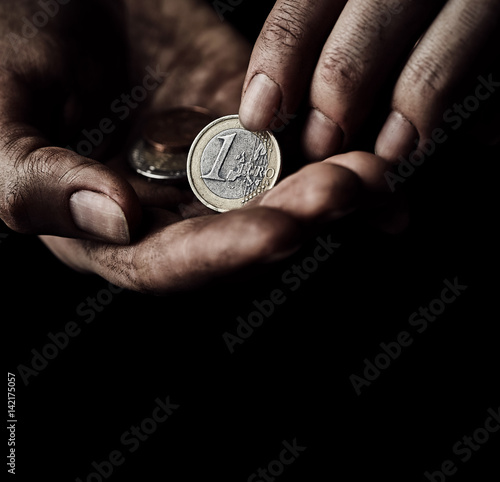 Hands of beggar with coin