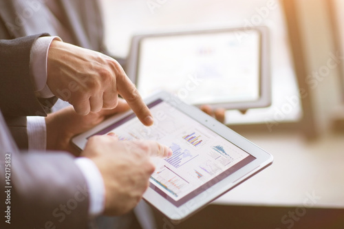 Hands of people working with tablet computer in office. Technology.