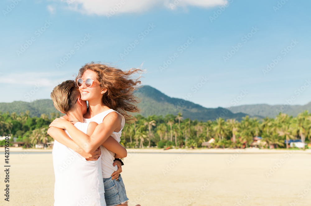 Happy couple hugging on the beach