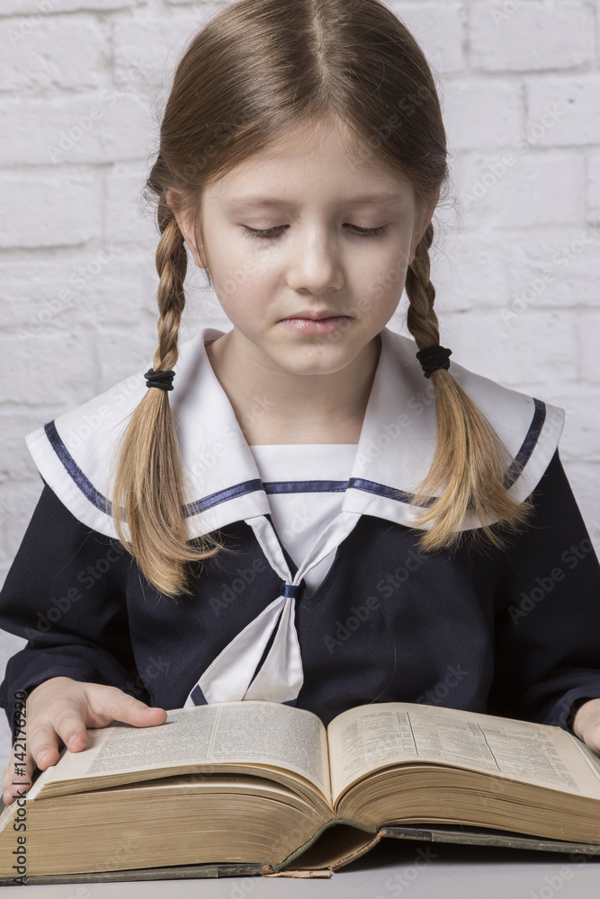 dziewczynka z książką w mundurku szkolnym - obrazy, fototapety, plakaty 