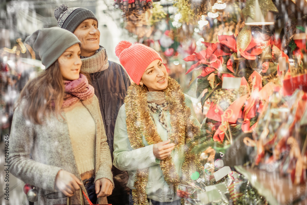 Smiling parents with teenage girl at counter with Poinsettia and  floral decorations