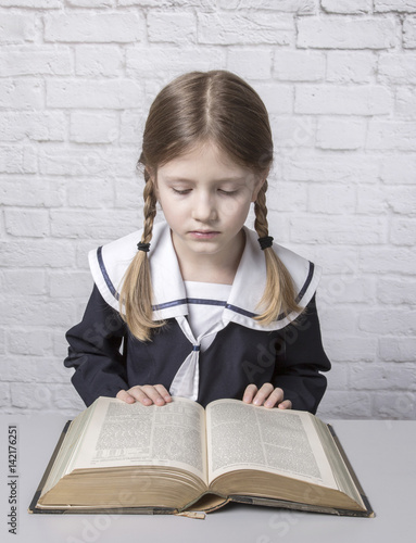 dziewczynka z książką w mundurku szkolnym