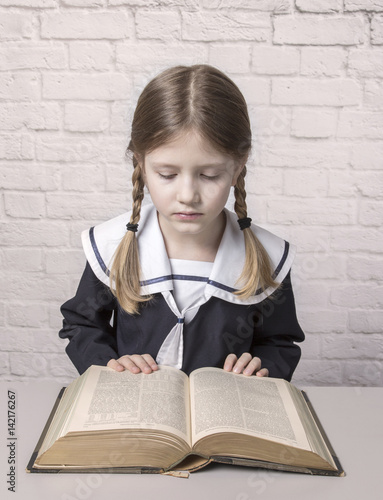 dziewczynka z książką w mundurku szkolnym