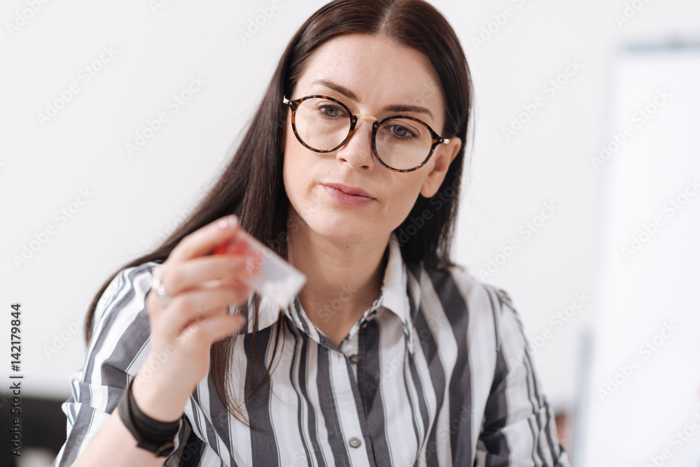 Attentive woman looking at her medicine Attentive woman looking at her medicine