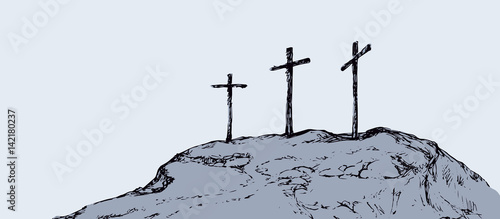 Three crosses stand on  light sky backdrop