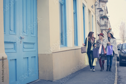 Three best friends walking on the street .