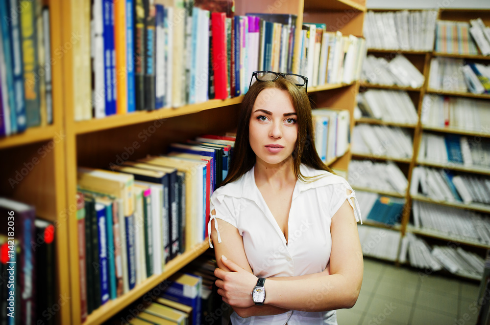 Brunette girl at library, wear on white blouse and black mini skirt. Sexy business woman or teacher concept. Brunette girl at library, wear on white blouse and black mini skirt. Sexy business woman or teacher concept.