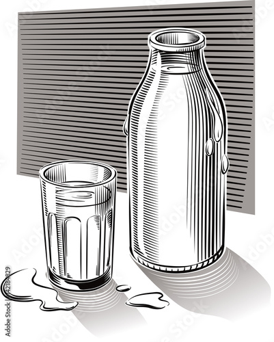 Glass and bottle of fresh pasteurized milk leaning on a table.
