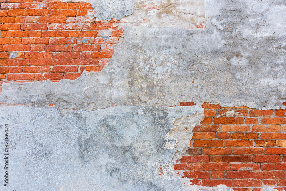 Fototapeta premium Old brick wall texture, covered with multiply stucco plaster layers, weathered and distressed