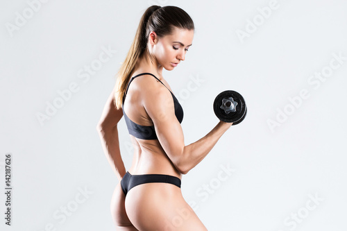 Fitness woman working out with dumbbell.