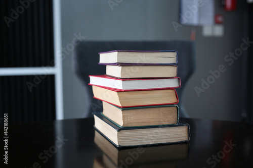stack of hardcover books on wooden table. Education background.