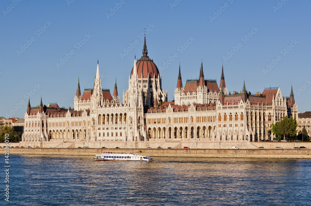 Pleasure boat on the Danube River passing by the Hungarian Parliament Building in Budapest, Hungary