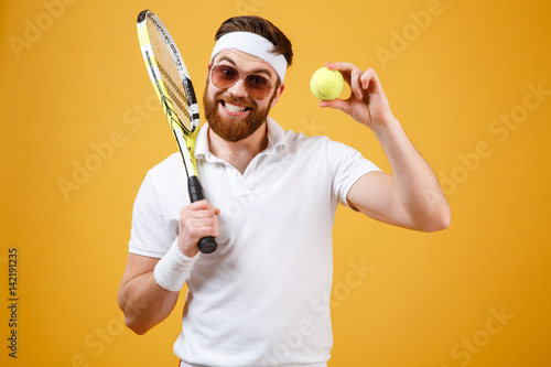 Happy young tennis player showing tennis ball. © Drobot Dean