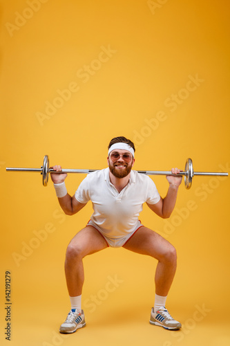 Happy young sportsman make sport exercises with barbell